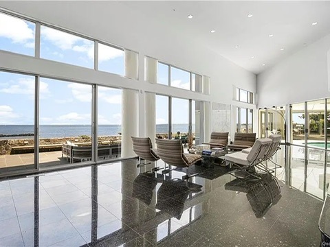 New Rochelle beach house in New York, living room with black tile floors overlooking the Long Island Sound