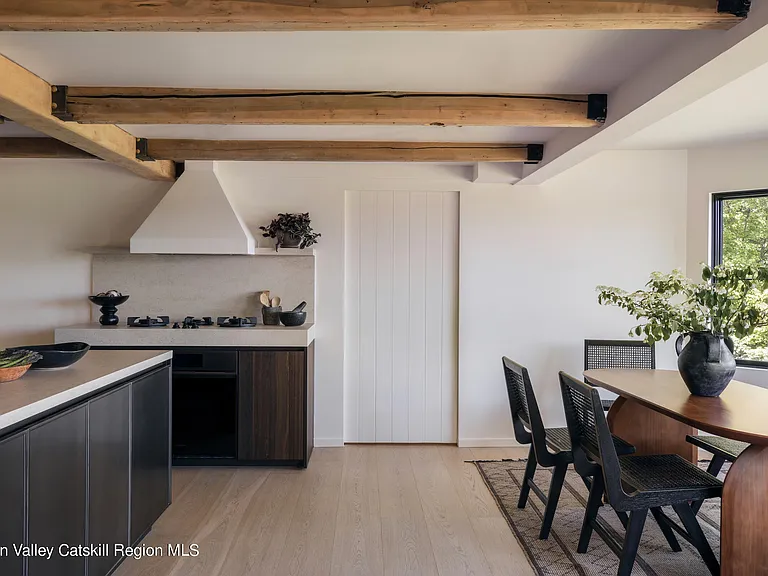 Highland, NY estate with neutral colors, neutral modern kitchen with black cabinets and exposed beams