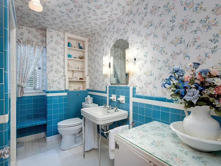 vintage Rock Island Illinois house, bathroom with vintage tilework and floral wallpaper with a white porcelain sink