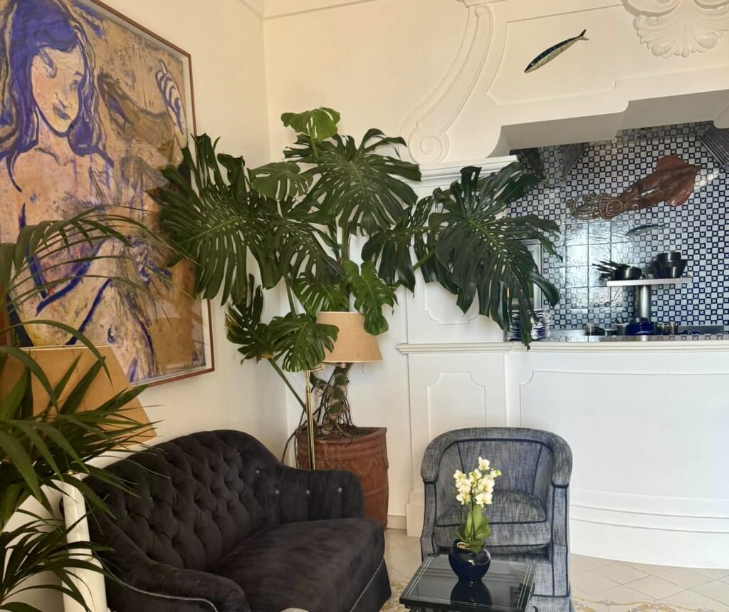 positano beach, hotel lobby with velvet seating and lush tropical plants