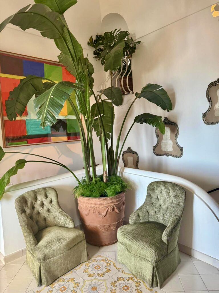 positano beach, hotel lobby with velvet seating and lush tropical plants