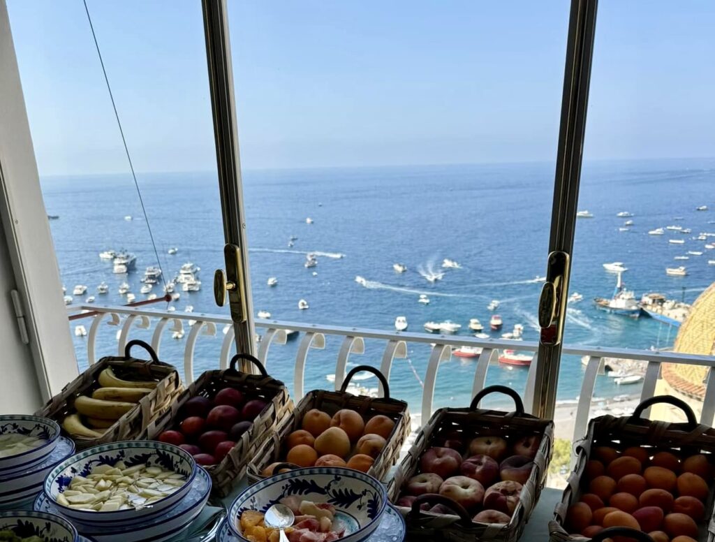 positano beach, hotel breakfast buffet with fresh italian fruits overlooking yachts in positano