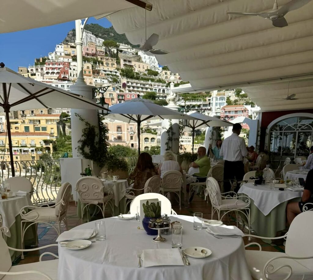 positano beach, hotel breakfast buffet with fresh italian fruits overlooking yachts in positano