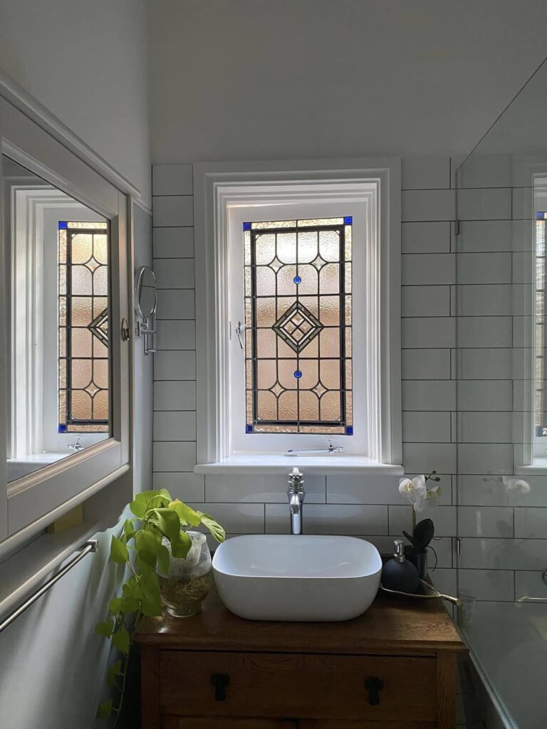 light bright rooms, bathroom with vintage windows, green plants and penny tile