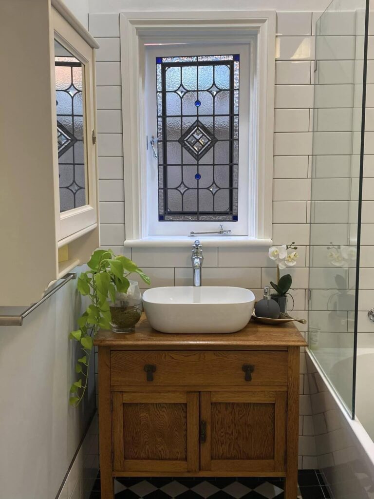 light bright rooms, bathroom with vintage windows, green plants and penny tile