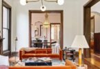 light bright rooms, vaulted ceilings with MCM light fixtures and rust orange sofa