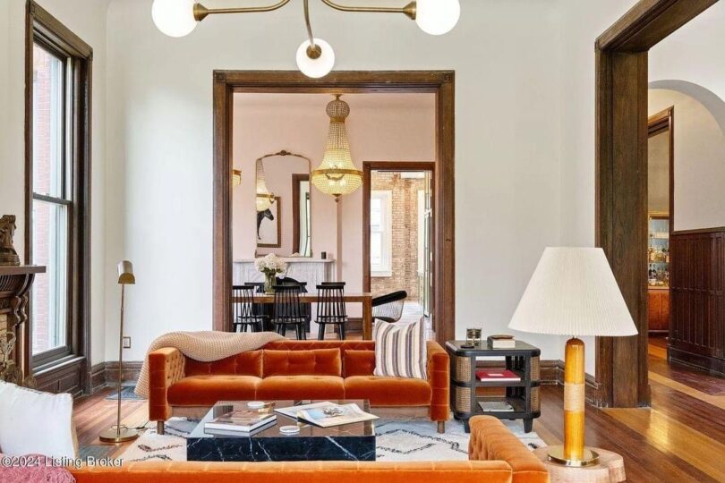 light bright rooms, vaulted ceilings with MCM light fixtures and rust orange sofa