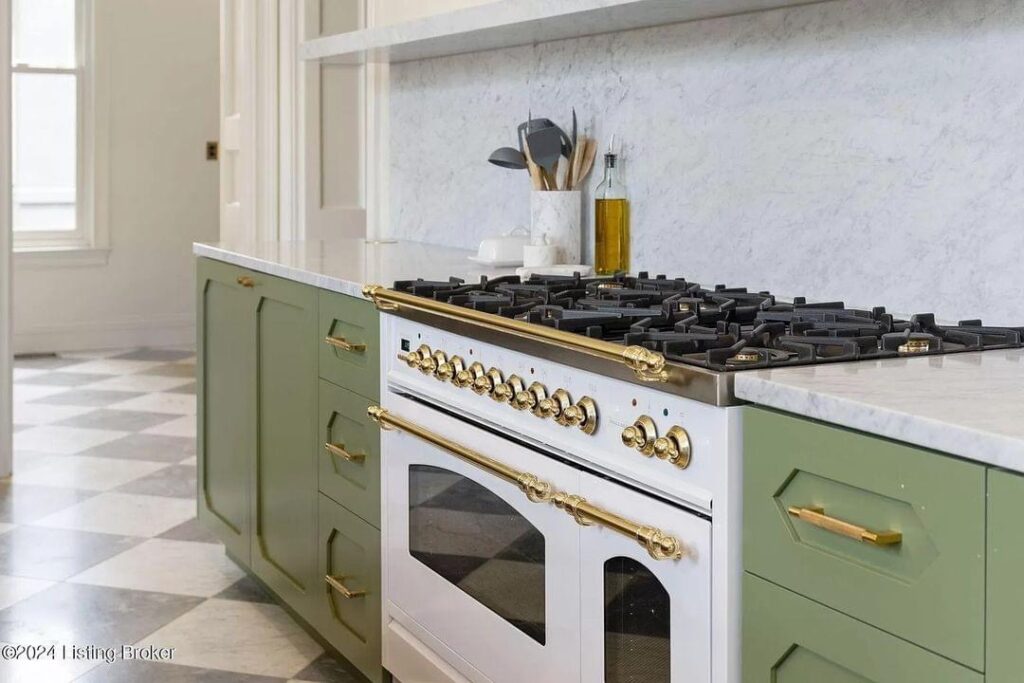 light bright rooms, sage green kitchen cabinets with checkerboard tile floors and wood with white marble center island and white and gold stove