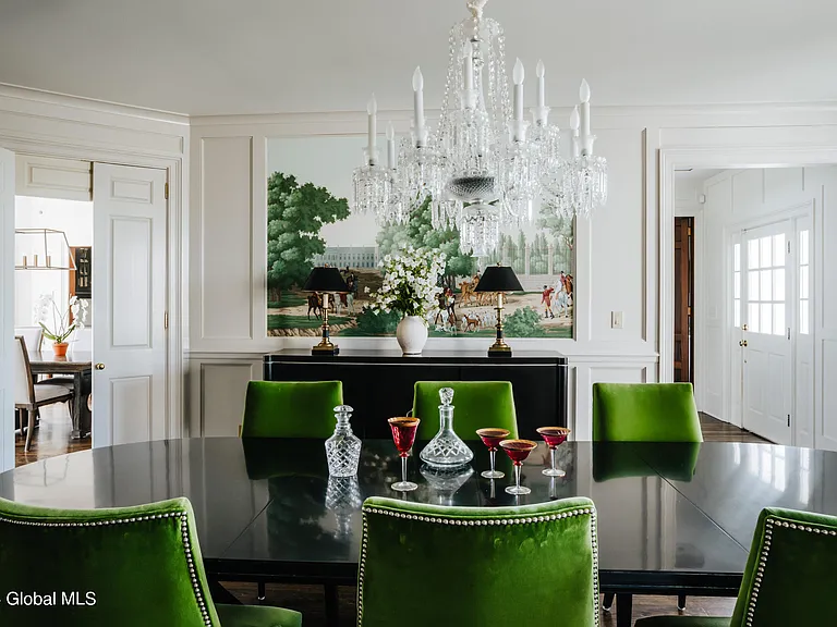 Valatie NY Equestrian Estate, modern industrial dining room with black dining room table and green velvet chairs with large chandelier