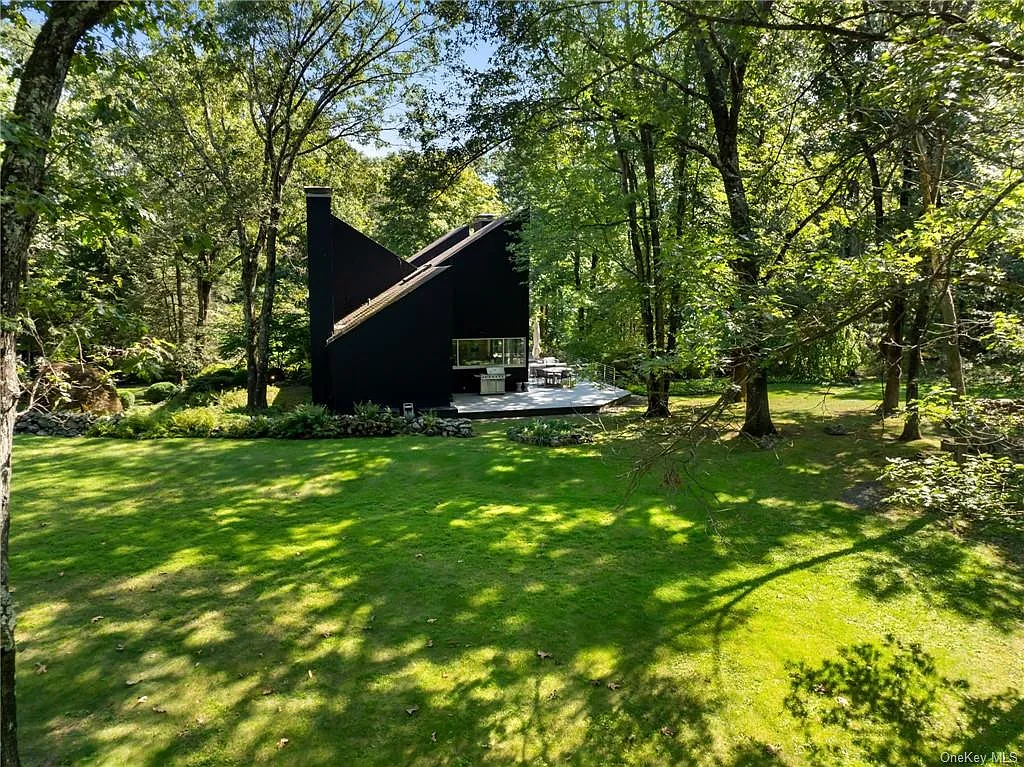 modern chappaqua, ny house, modern black exterior paint with large windows and dark decking