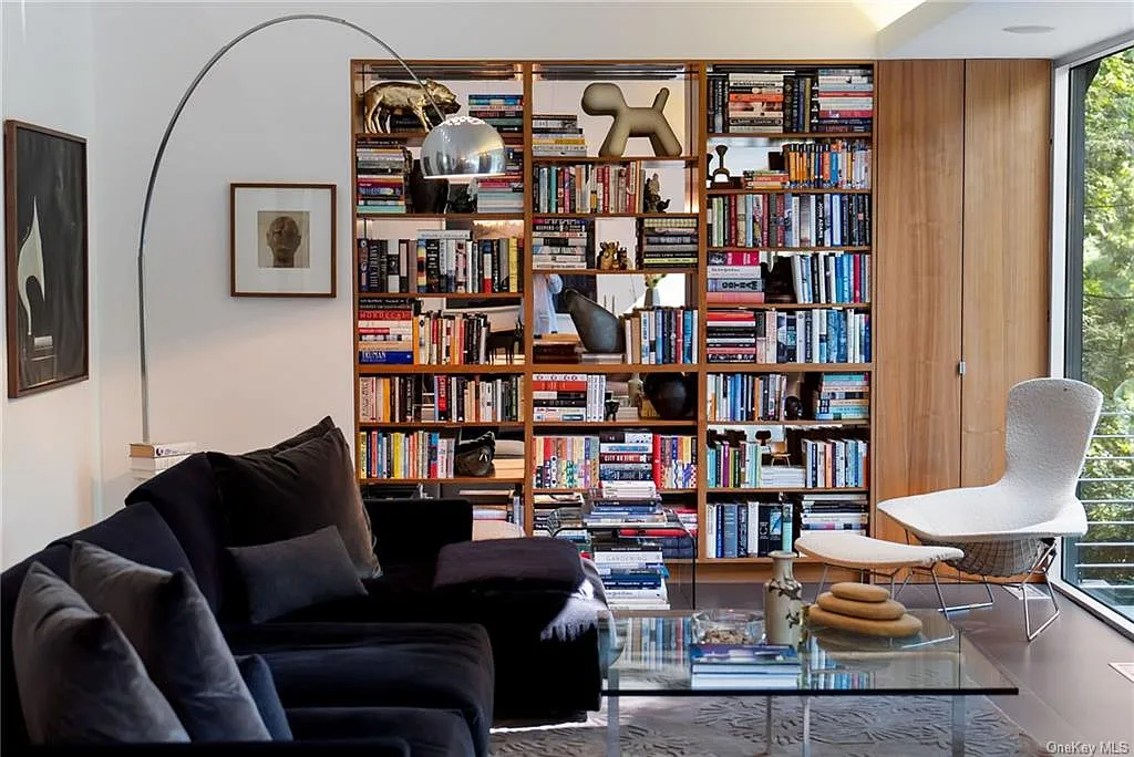 modern chappaqua, ny house, modern interior design with black sofa and vaulted ceilings and large library with bookshelves