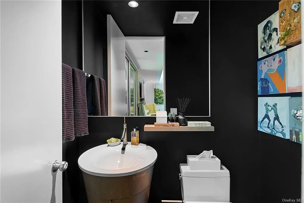 modern chappaqua, ny house, modern interior design bathroom with black tile and pedestal sink