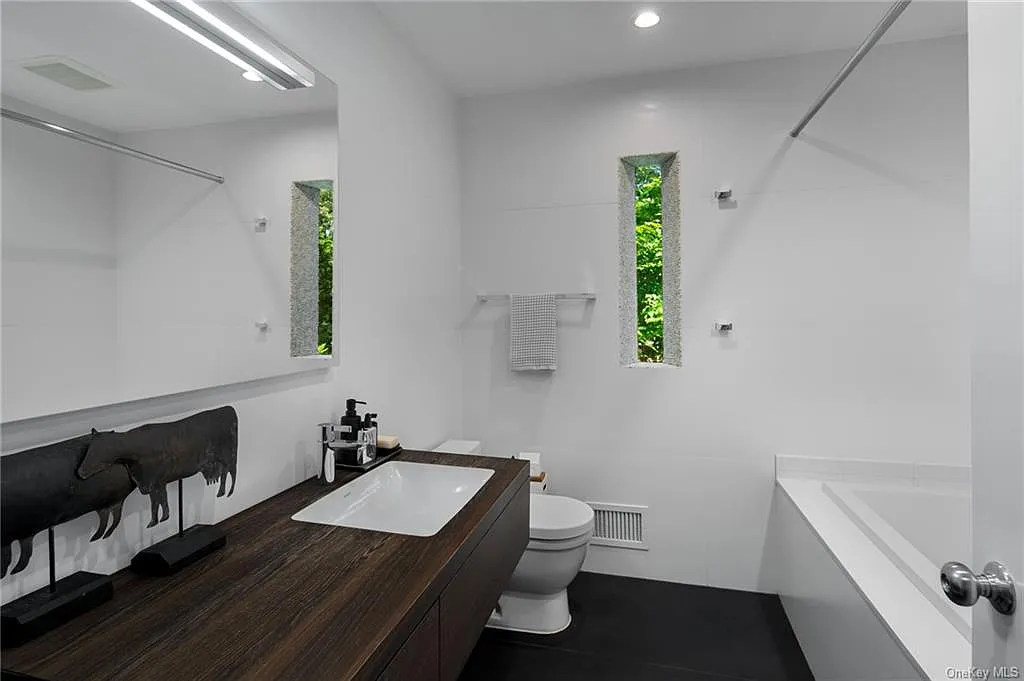 modern chappaqua, ny house, modern interior design bathroom with soft black tile and a double vanity