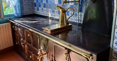 claude monet's kitchen in giverny france, with rich metal and blue tile finishes