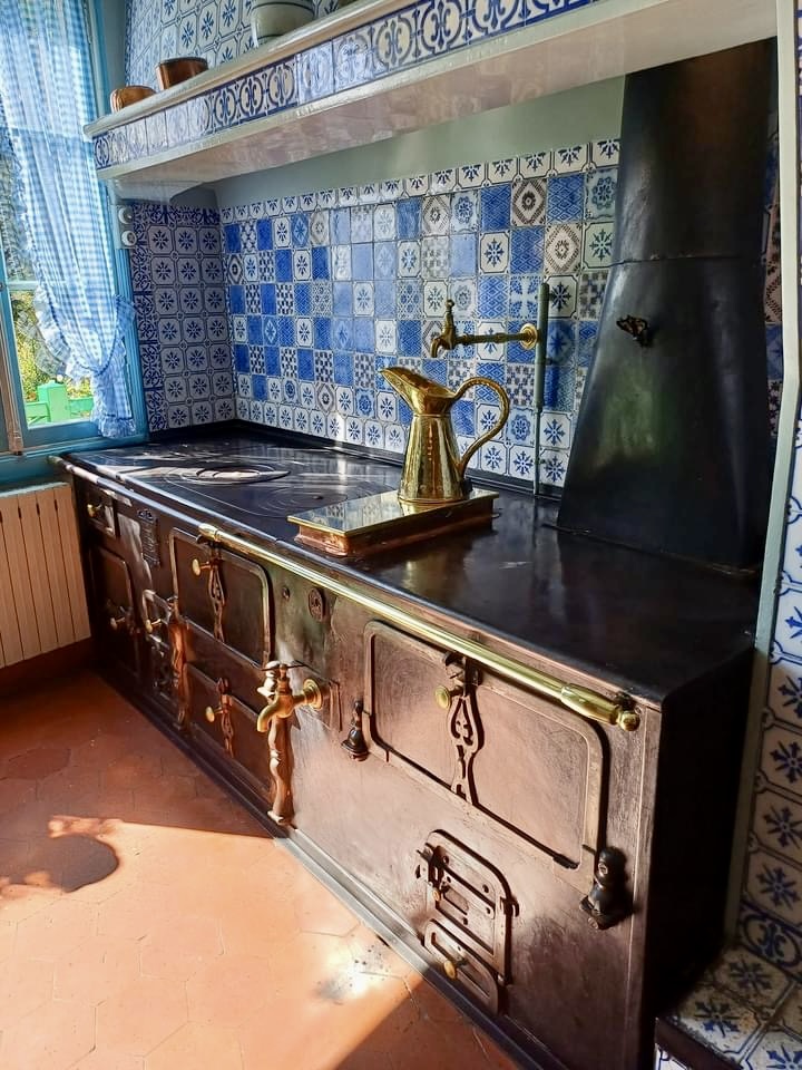 claude monet's kitchen in giverny france, with rich metal and blue tile finishes