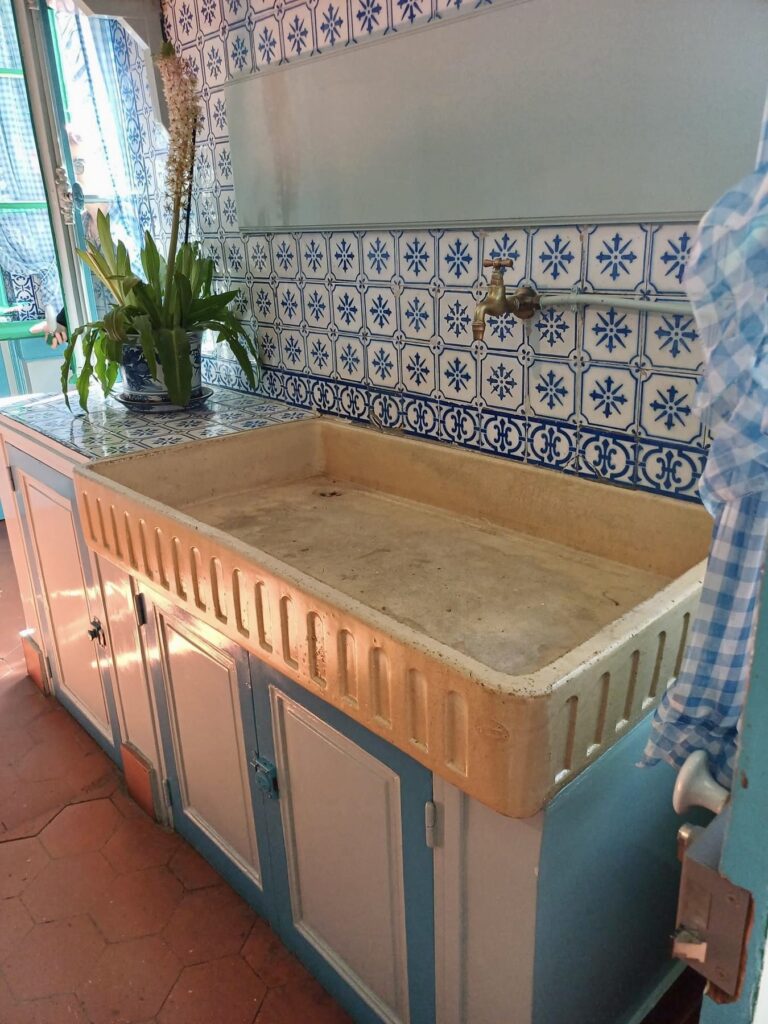 claude monet's kitchen in giverny france, with rich metal and blue tile finishes