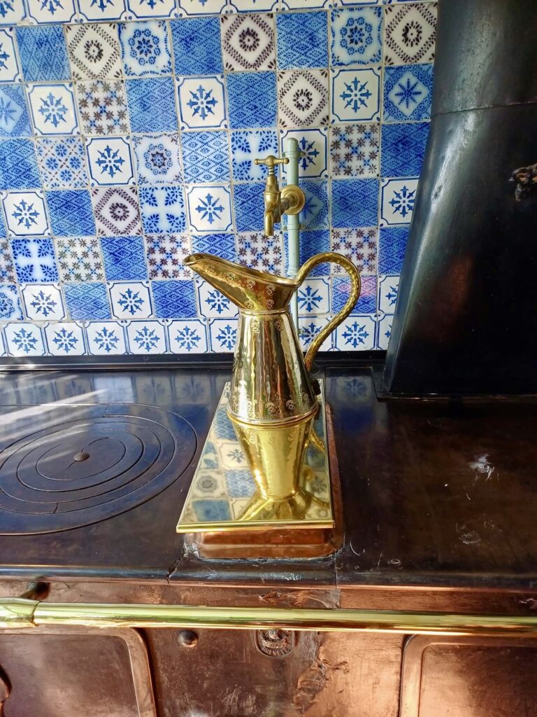 claude monet's kitchen in giverny france, with rich metal and blue tile finishes