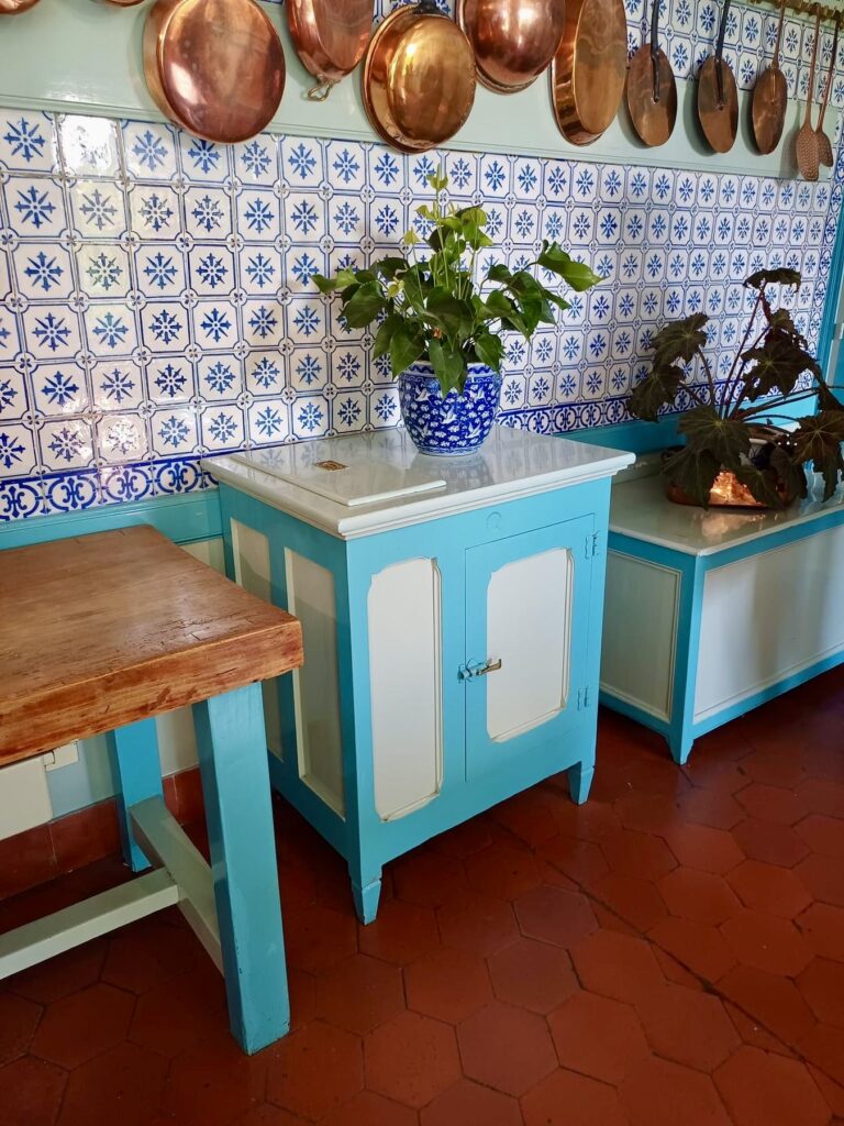 claude monet's kitchen in giverny france, with rich metal and blue tile finishes