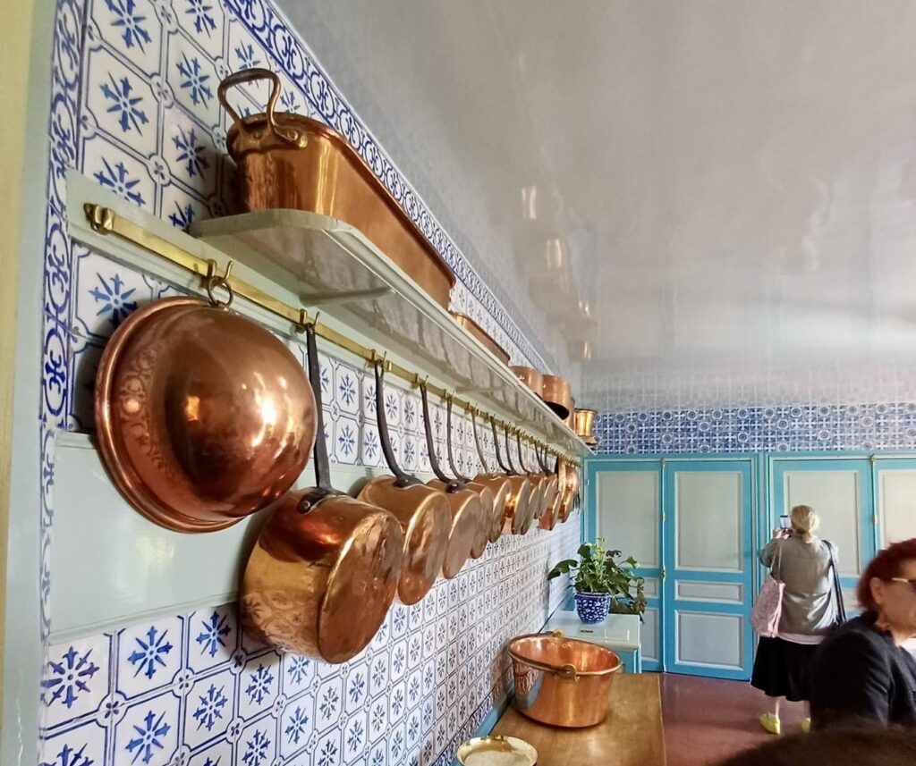 claude monet's kitchen in giverny france, with rich metal and blue tile finishes