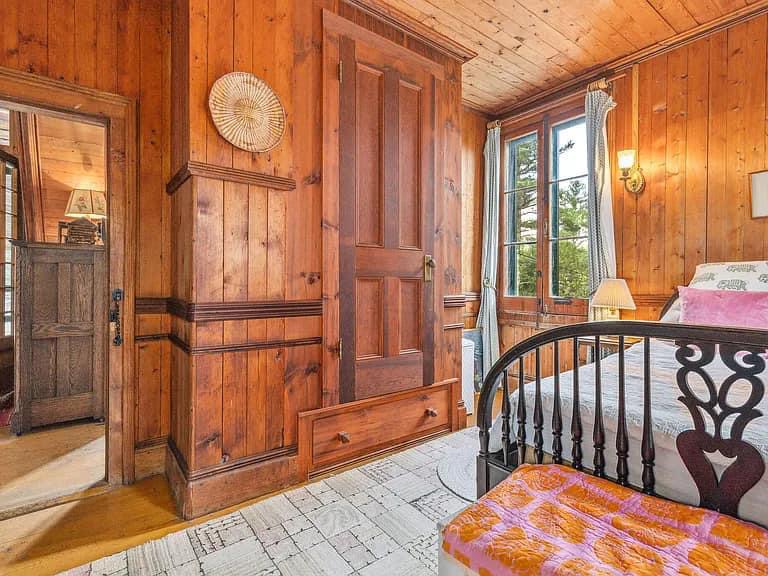 Keene Valley NY house with wood walls and vintage black rail bed