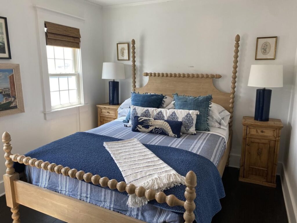 light bright rooms, modern navy blue and cream coastal decor bedroom with four poster bed and quilted throw pillows