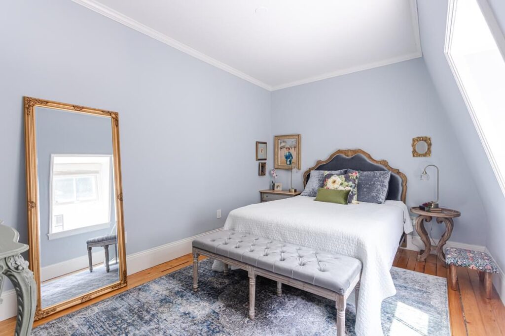 light bright rooms, modern neutral master bedroom with vintage slate blue persian area rug and textured bedspread with victorian headboard