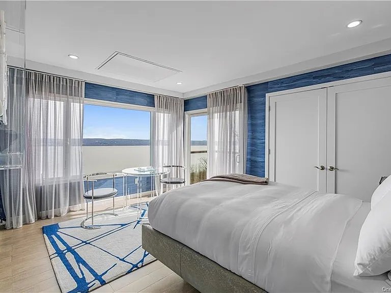 Modern Nyack, NY Palace with windows overlooking the hudson river, sleek modern guest bedroom with blue walls and scenic Hudson River views with loads of natural light