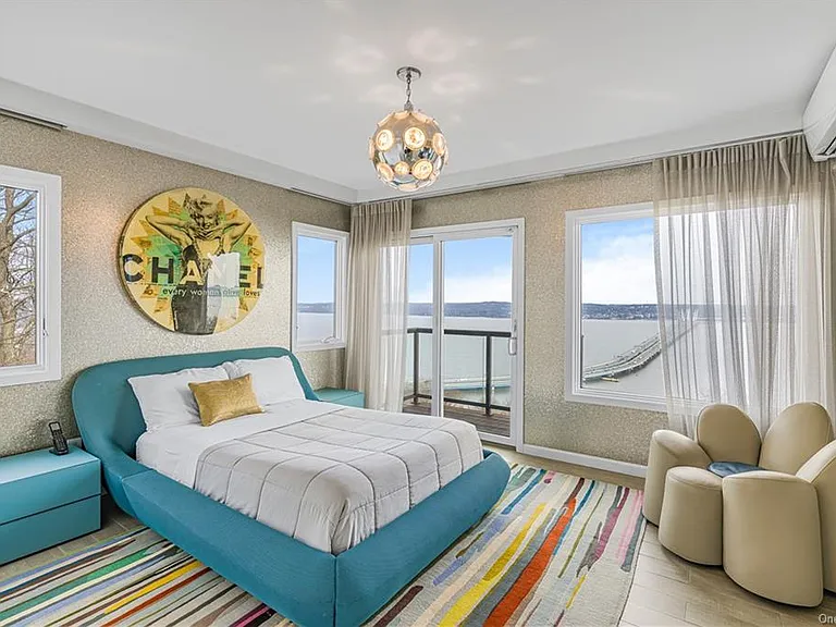 Modern Nyack, NY Palace with windows overlooking the hudson river, sleek modern bedroom with turquoise bed