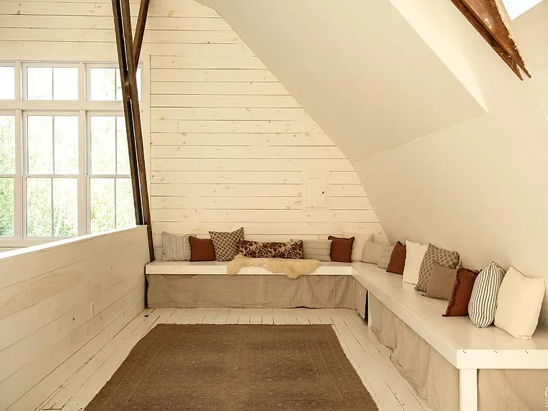 converted dairy barn in accord ny, modern country reading nook with natural light around built-ins and vaulted ceilings