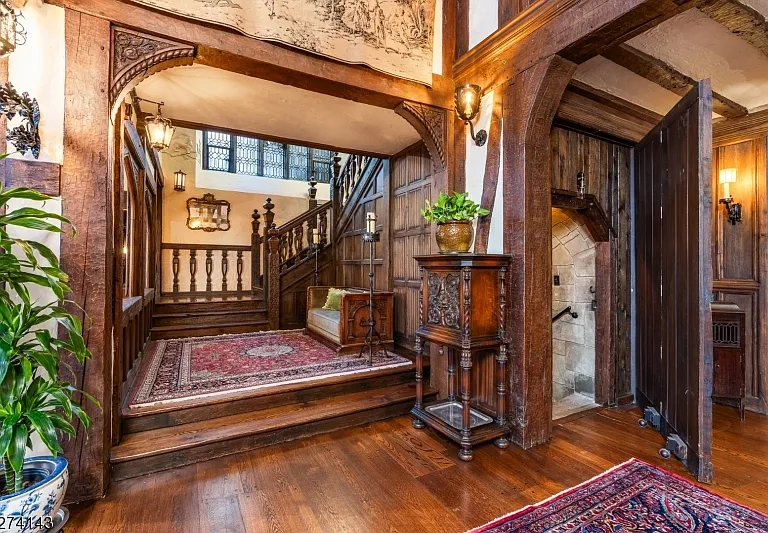 tudor style castle in NJ, large foyer with dark wood detailing and stairs