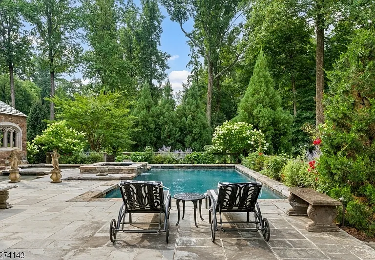 tudor style castle in NJ, stone in-ground pool with adirondack chairs