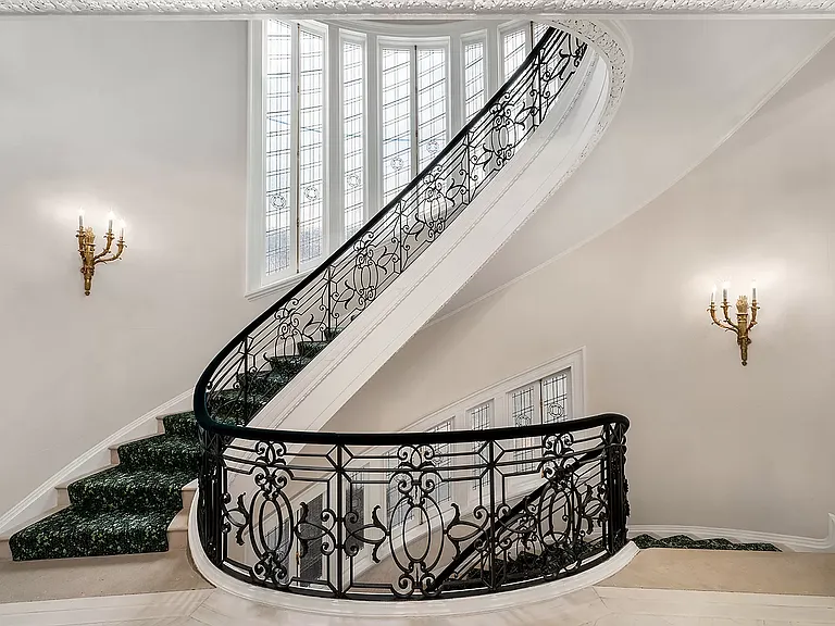 fifth ave nyc mansion listed for $58 million, interior of 973 fifth avenue with massive spiral staircase