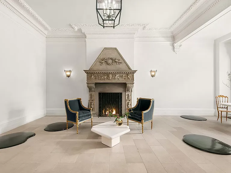 fifth ave nyc mansion listed for $58 million, interior of 973 fifth avenue with massive limestone fireplace and vaulted ceilings