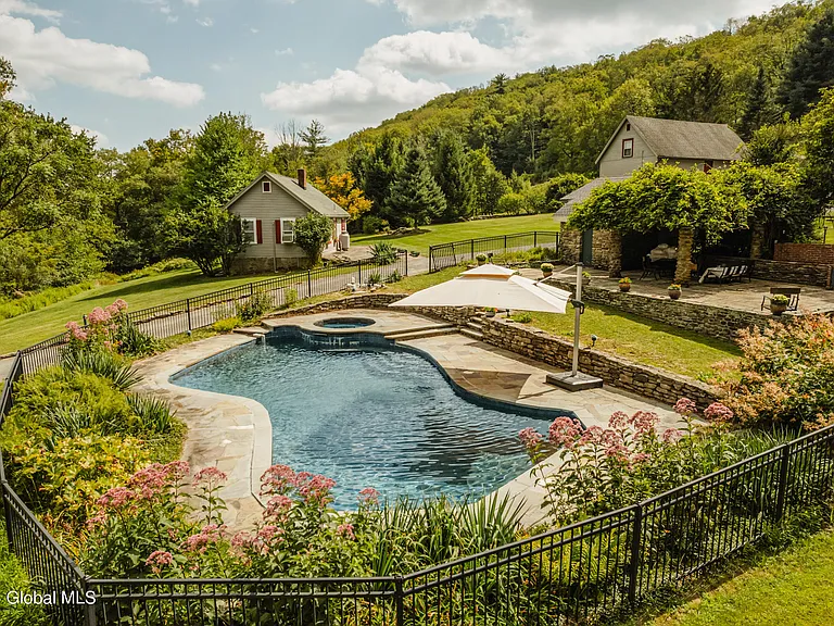 massive catskills ny castle for sale in sullivan county, stone and brick exterior overlooking the catskill mountain range and hudson valley with a kidney shaped in ground pool