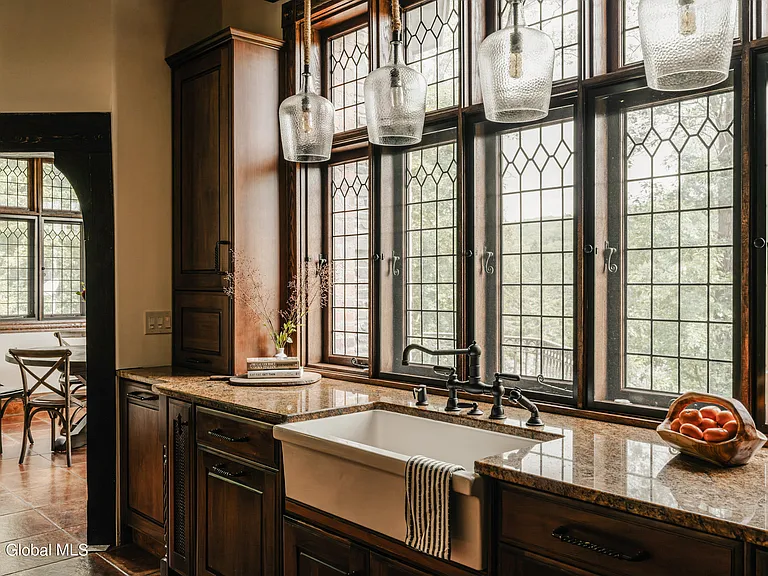 massive catskills ny castle for sale in sullivan county, tudor style kitchen with pendant lights and leaded glass windows