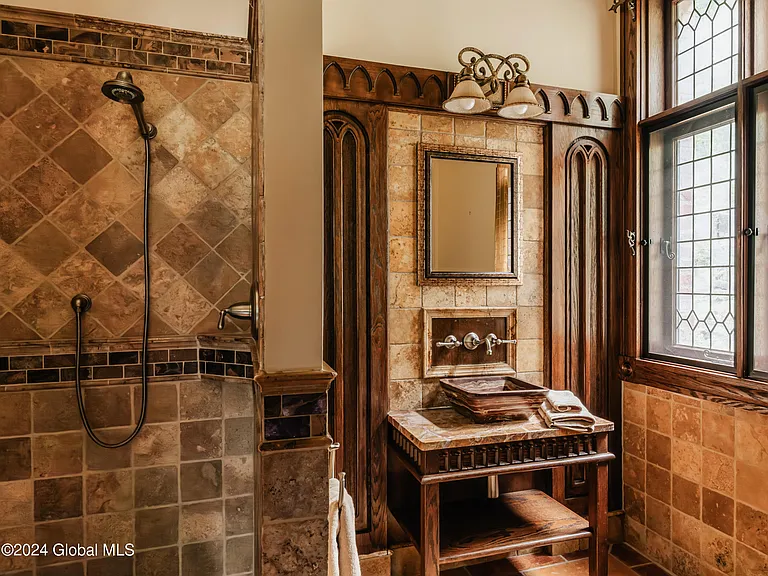 massive catskills ny castle for sale in sullivan county, tudor style master bathroom with tuscan tile with multiple showerheads and dark wood cabinetry