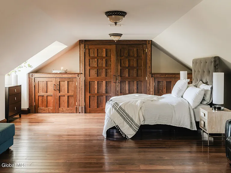 massive catskills ny castle for sale in sullivan county, tudor style master bedroom with vaulted ceilings and dark wood beams and a hand carved wood bedframe