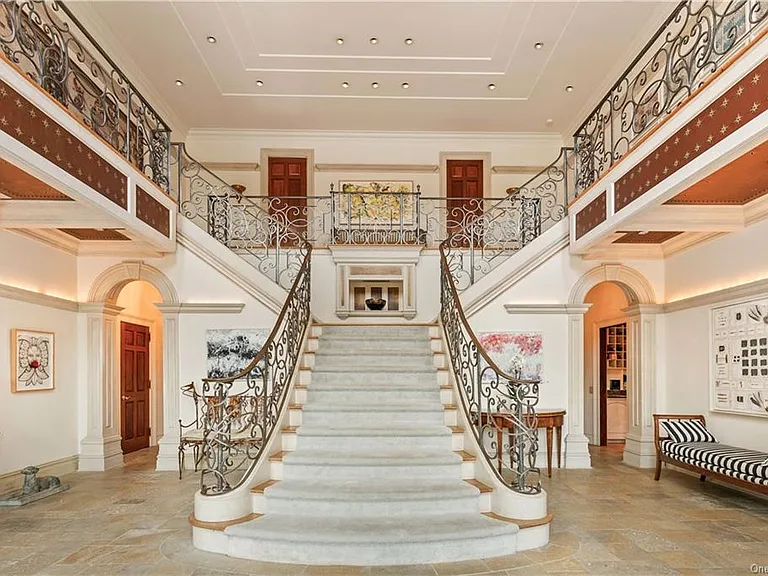 eclectic castle in new york, interior of the Salutation Castle replica with massive double staircases in the foyer