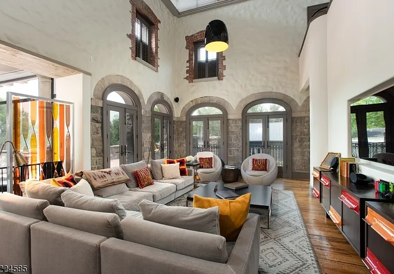 19th-Century Castle in New Jersey, exterior of a massive stone castle in Bernardsville NJ with a large modern living room and vaulted two-story ceilings