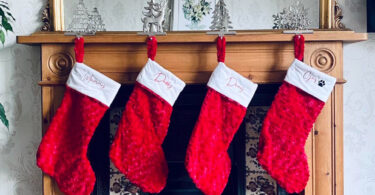 stocking stuffer ideas for men, red christmas stockings hung on the fireplace mantle