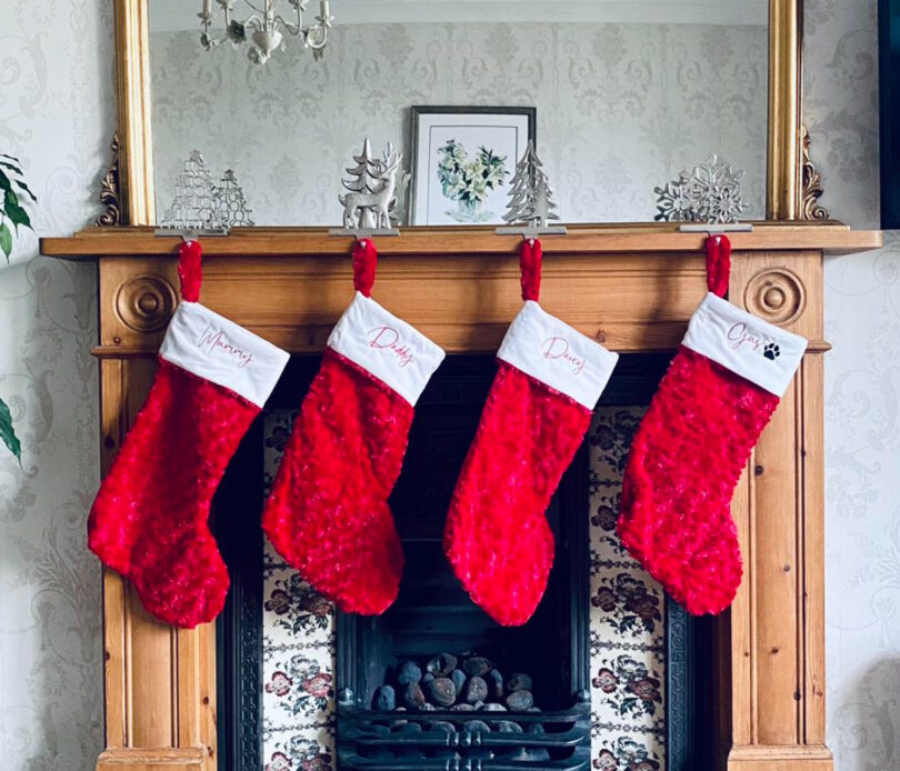 stocking stuffer ideas for men, red christmas stockings hung on the fireplace mantle