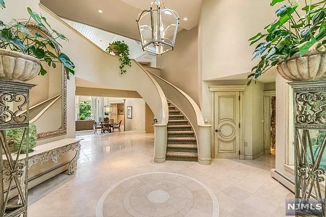 interior of a posh modern saddle river mansion in New Jersey's Bergen County, spiral marble bridal staircase in a modern foyer