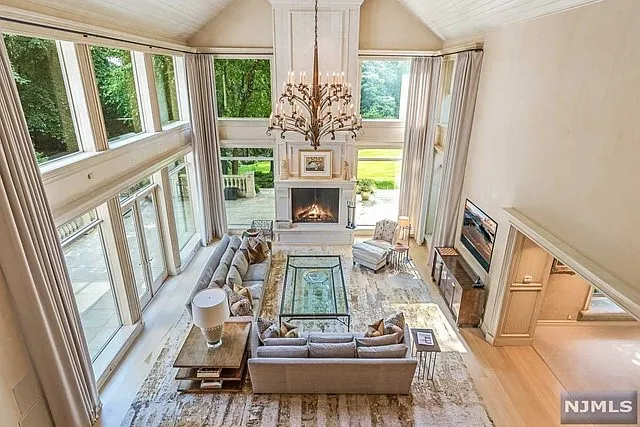 interior of a posh modern saddle river mansion in New Jersey's Bergen County, large modern living room with vaulted ceilings and beige finishes