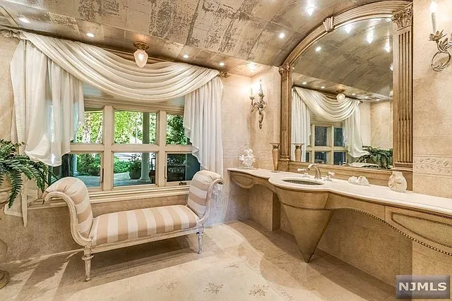 interior of a posh modern saddle river mansion in New Jersey's Bergen County, large master bathroom with soaking tub and marble finishes