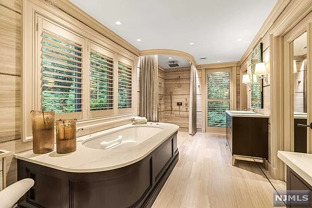 interior of a posh modern saddle river mansion in New Jersey's Bergen County, large wood and marble bathroom with modern soaking tub