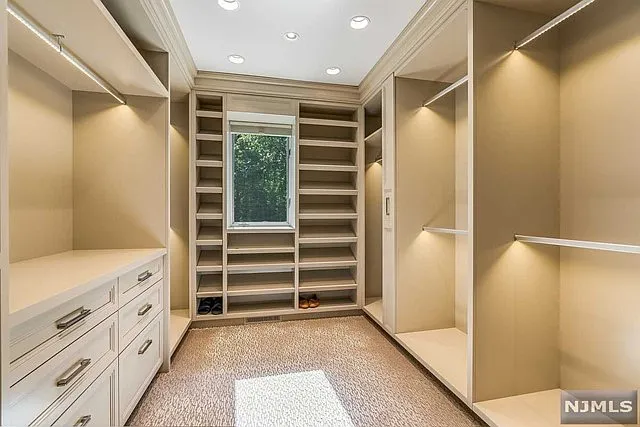 interior of a posh modern saddle river mansion in New Jersey's Bergen County, massive walk-in closet with beige finishes