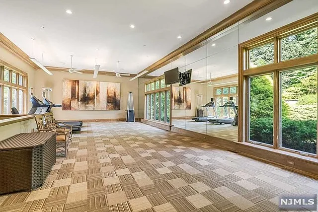 interior of a posh modern saddle river mansion in New Jersey's Bergen County, large entertainment room with glass wall overlooking saddle river new jersey