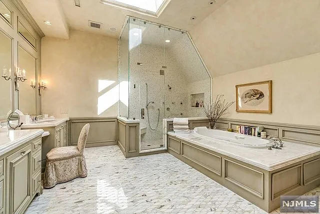 interior of a posh modern saddle river mansion in New Jersey's Bergen County, large master bathroom with soaking tub and marble finishes