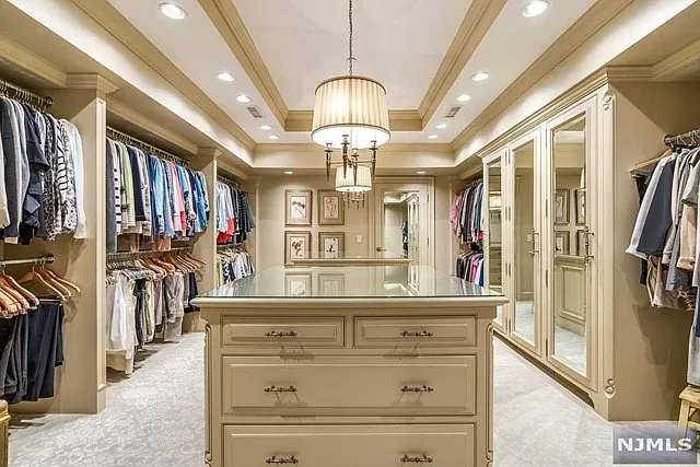 interior of a posh modern saddle river mansion in New Jersey's Bergen County, large walk-in closet with loads of beige built-ins