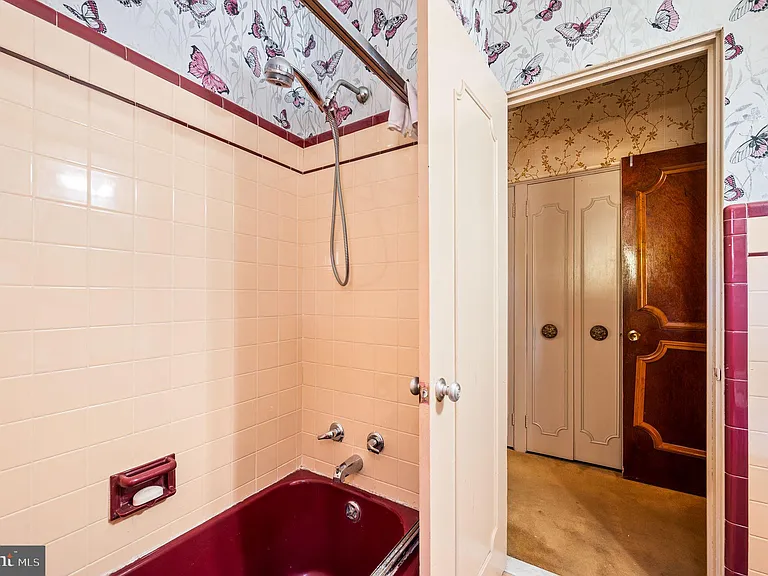 Philly home of boxer Muhammad Ali and family, midcentury modern home interior with original pink tile  and red tub bathroom in Morris Park Philadelphia